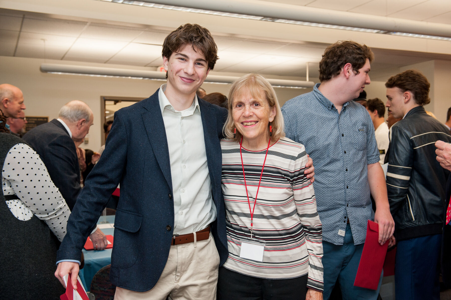 Two people put their arms around each other for a photograph: a young student (left) wearing a dark blazer and smiling, and BCF Scholarship Committee Chair Ann Coles (right) who is wearing a striped sweater.